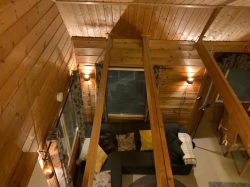 einen Blick über ein Wohnzimmer in einem Baumhaus in der Unterkunft Saunaharju 5 järven rannalla in Kolinkylä