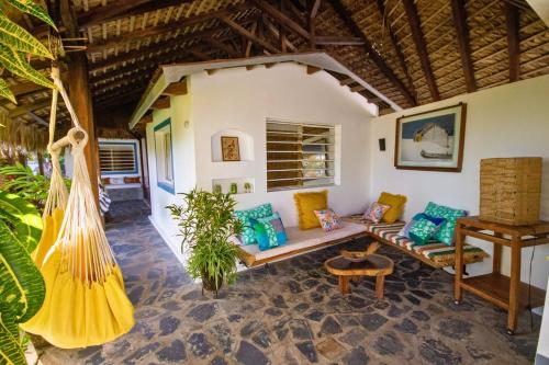 a living room with a couch and a hammock at MADIROKELY HOUSE Nosy Be in Ambatoloaka