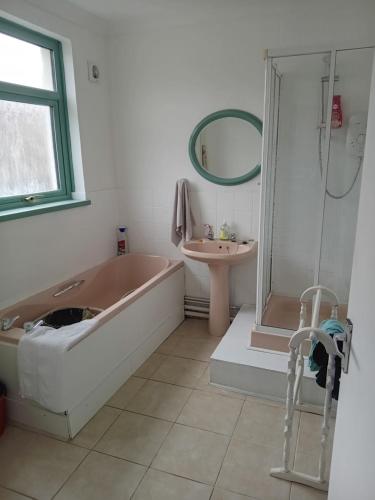 bagno con vasca e lavandino di Cottage Style in Ystrad, Double room a Llwyn-y-pia