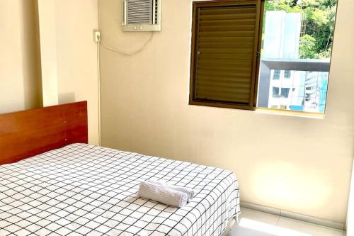 ein Schlafzimmer mit einem Bett und einem Kissen darauf in der Unterkunft 100m da Rodoviaria, 600m da UFV, Ar Condicionado, Elevador e Garagem Paga in Viçosa