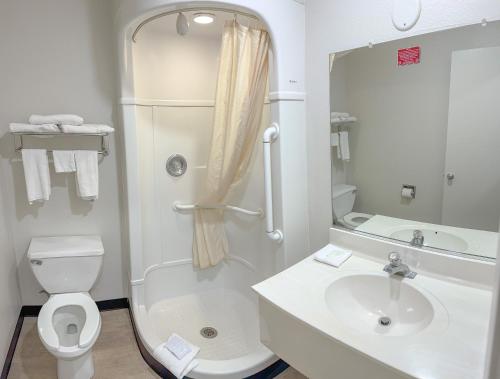 a bathroom with a shower and a toilet and a sink at Super 7 Motel in Coralville