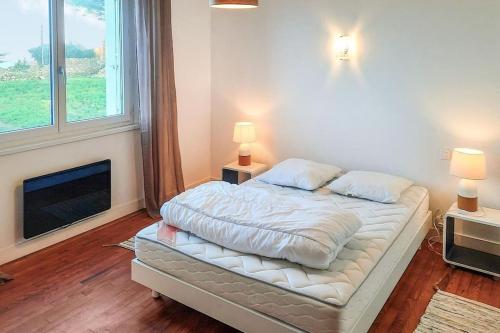 ein Schlafzimmer mit einem Bett mit zwei Kissen und einem Kamin in der Unterkunft Maison de location Pengourven in Plouguerneau