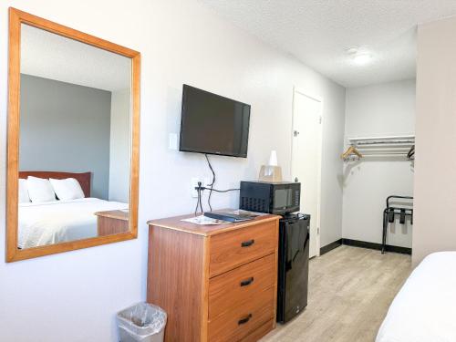 um quarto com uma cama e uma televisão numa cómoda em Super 7 Motel em Coralville