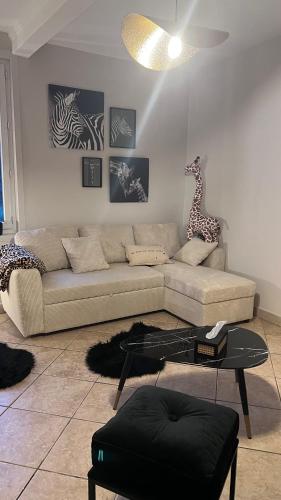 - un salon avec un canapé et une girafe sur le mur dans l'établissement Gite 6 personnes Ailly le Haut Clocher, à Ailly-le-Haut-Clocher