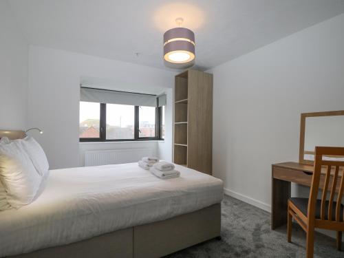 a bedroom with a bed with a desk and a window at Flat 32 - Marine Court in Littlehampton