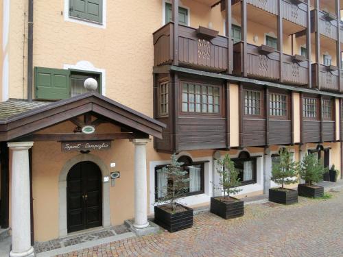 a building with potted plants in front of it at Sport Campiglio Apartment in Madonna di Campiglio