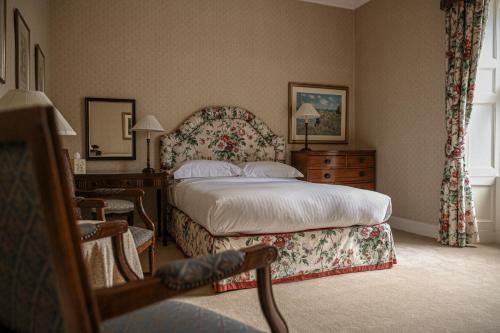 a bedroom with a bed and a dresser and a window at Kinloch House Hotel in Blairgowrie