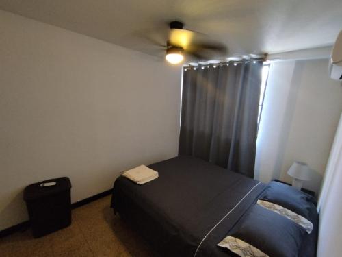 a bedroom with a bed and a ceiling fan at Cuarto por la via españa, con aire in Panama City