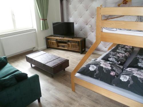 ein Wohnzimmer mit einem Etagenbett und einem TV in der Unterkunft Haus Adelheid in Weil am Rhein
