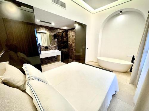 bagno con letto, vasca e lavandino di Al Capri Suite Isola di Capri a Capri