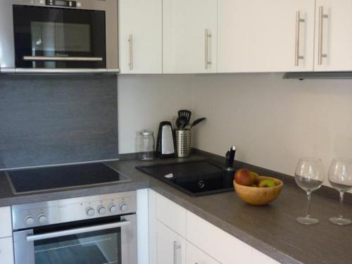 a kitchen with a bowl of apples and two wine glasses at Ferienwohnung am Pfarrhof in Ziethen