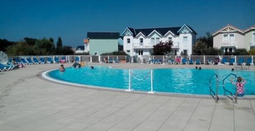 une grande piscine avec des personnes assises autour de celle-ci dans l'établissement Le Parc, à Talmont-Saint-Hilaire