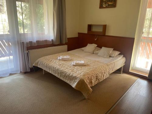 - une chambre avec un lit et 2 serviettes dans l'établissement Willa Stenia Apartamenty, à Wisła