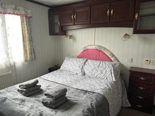 a bedroom with a bed with pillows on it at 49 Tay - The Cottage Caravan in Angus