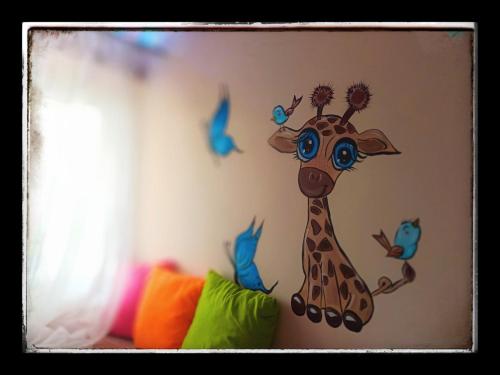 a painting of a giraffe on a wall at SOTIRIA APARTMENT in Kiáton