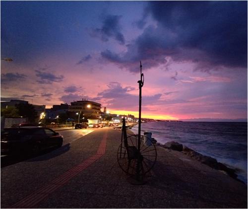 a bike parked on the side of a street at sunset at SOTIRIA APARTMENT in Kiáton