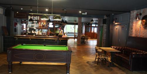 a pool table in a room with a bar at Fountain Hotel in London