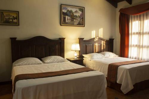 Ciudad ViejaにあるCasa tipo Colonialのベッド2台と窓が備わるホテルルームです。