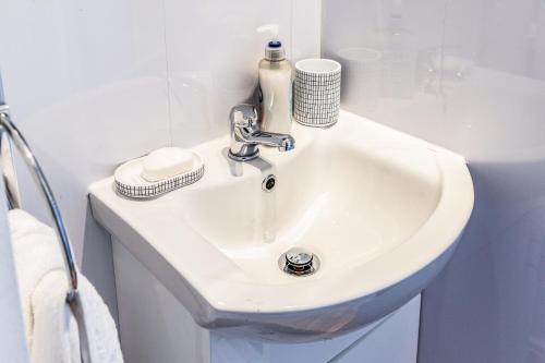 a white sink in a white bathroom at Stylish 2 bed house 7mins to Manchester City center in Manchester
