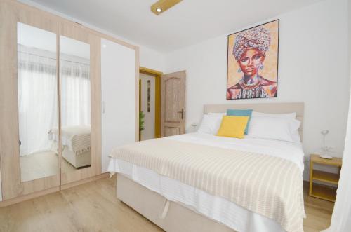 een slaapkamer met een bed met een schilderij aan de muur bij DC Apartment C in Kotor