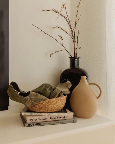 a vase sitting on top of books next to a vase at Boulder Surrounded Escape- ANOTHERdeserthouse in Yucca Valley