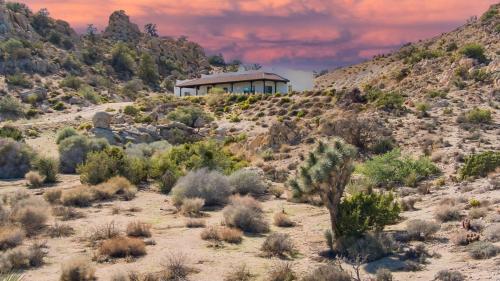 a house on the side of a hill in a desert at Boulder Surrounded Escape- ANOTHERdeserthouse in Yucca Valley