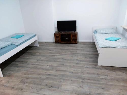 a room with two beds and a flat screen tv at L8 Street-Kaiserslautern-Monteurwohnung-Worker's apartment in Kaiserslautern