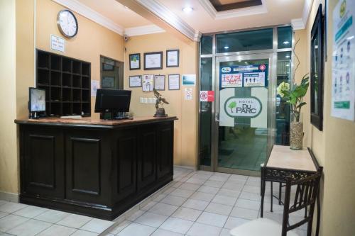 une salle d'attente avec un comptoir et une horloge sur le mur dans l'établissement Hotel Du Parc, à Poza Rica de Hidalgo