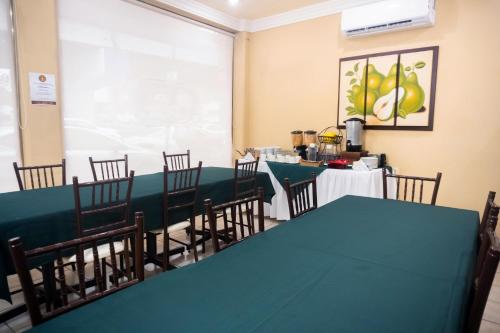 uma sala de jantar com uma mesa verde e cadeiras em Hotel Du Parc em Poza Rica de Hidalgo