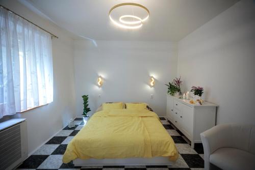 ブダペストにあるBirdnest Apartmentの白いベッドルーム(黄色のベッド1台、窓付)