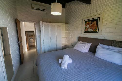 a bed with two white towels on it in a room at Residencial Tropical in Florianópolis