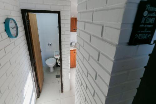 a bathroom with a door and a toilet in a room at Residencial Tropical in Florianópolis