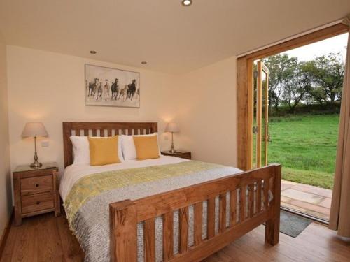 Durley的住宿－Nettlebed Farm Holiday Lets Barn3，一间卧室设有一张大床和一个滑动玻璃门