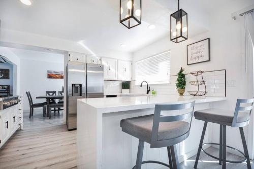 a kitchen with a white counter and chairs in it at Large Monterey Bay House close to Aquarium, Golf in Seaside