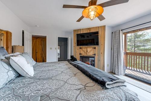 a bedroom with a large bed with a ceiling fan at Alpine Getaway with Grill Walk to Lake! in Sapphire