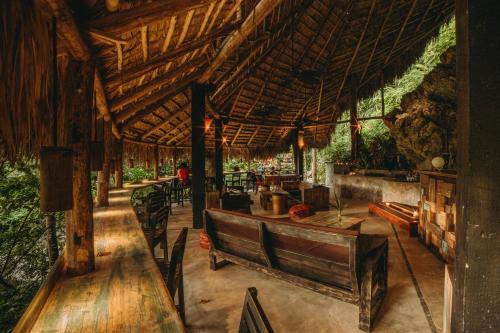 a restaurant with wooden tables and chairs and a wooden roof at ZÂRIA Hotel & Retreat Center in El Valle