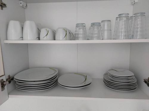 a bunch of plates and cups on shelves in a kitchen at L8 Street - Hellmut-Hartert-Straße in Kaiserslautern