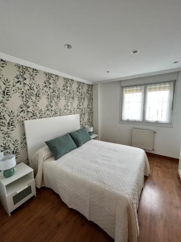 Un dormitorio con una cama grande y una pared en Apartamento Fana, en Cangas de Onís