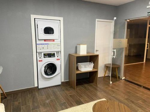 a laundry room with a washer and a washing machine at Flat Aconchegante 1 in Sorocaba