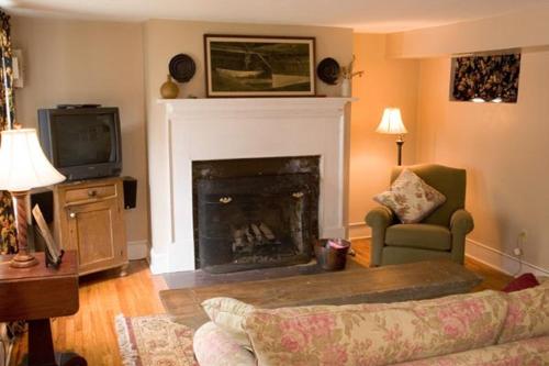 a living room with a fireplace and a tv at The Lafayette Inn & Restaurant in Stanardsville