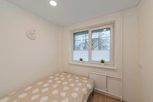 a bedroom with a bed and two windows at Luminious apartment with balcony by Polo Apartments in Kaunas
