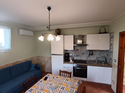 a kitchen and a living room with a blue couch and a table at Abbentu in Zafferana Etnea