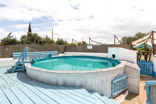 uma grande piscina com um deque de madeira e uma banheira de hidromassagem em Algarve, Quinta Estacao Alcantarilha - Casa 1 em Alcantarilha