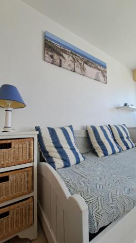 une chambre avec un lit avec des oreillers bleus et blancs dans l'établissement PLEINE MER - Studio Vue mer à 30m de la plage, à Saint-Jean-de-Monts