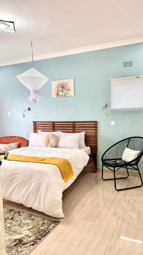 a bedroom with a large bed and a chair at Chaya accommodation B&B and self catering in Mzuzu