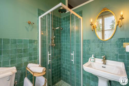 a green bathroom with a sink and a shower at Domaine du Chateau Vert in Hondainville