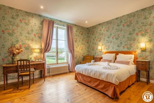 a bedroom with a bed and a desk and a window at Domaine du Chateau Vert in Hondainville