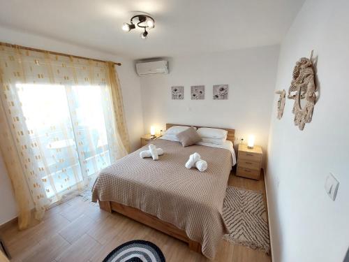 a bedroom with a bed with two towels on it at Afandou Square Apartment in Afantou