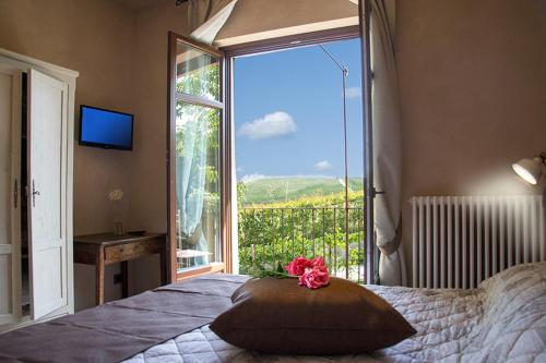 a bedroom with a bed and a large window at Villa Laura in Castellinaldo