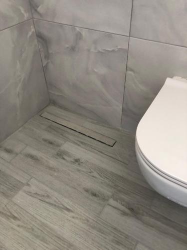 a bathroom with a toilet and a tile floor at Antonis Hotel in Kefalos